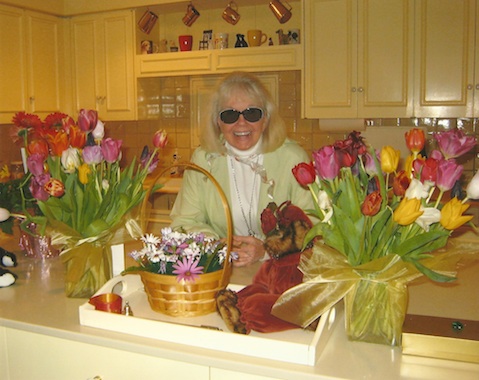 Doris in her newly decorated kitchen, surrounded by tulips from an adoring fan